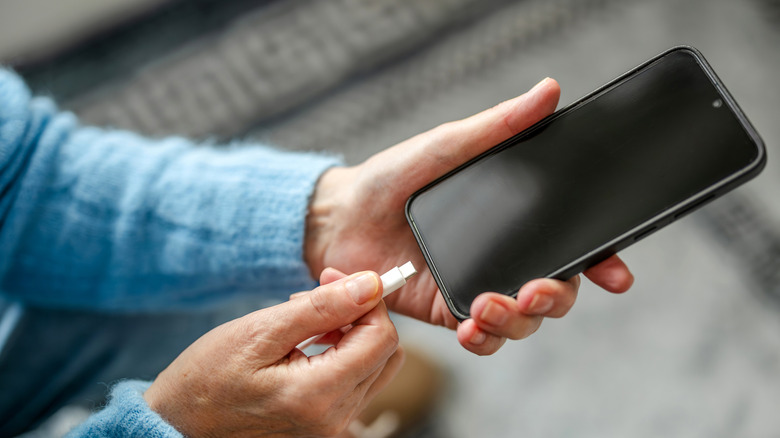 A person plugging in a black iPhone