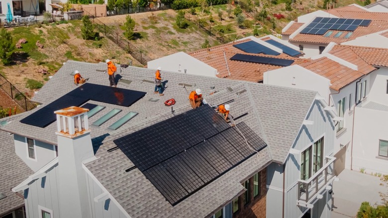 Men installing QCELLS solar panels on a home.