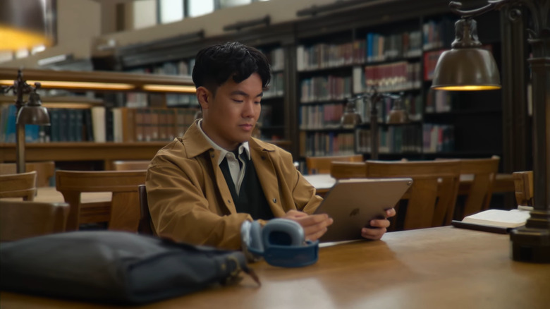 Man using iPad inside library