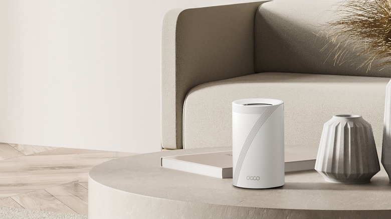 TP-Link Deco BE11000 placed on a coffee table in a living room
