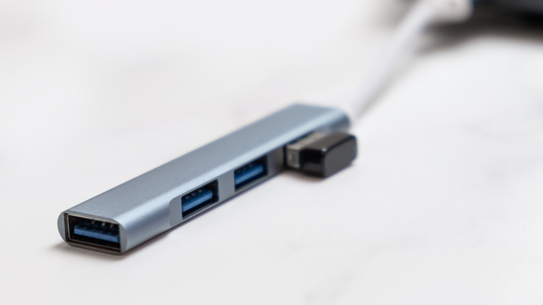 A USB hub attache to a computer, blurred in the background