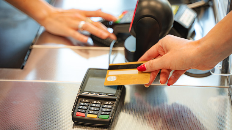 Someone paying at register with a credit card.