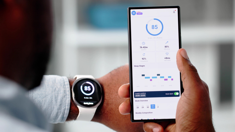 A person using a smartwatch along with a smartphone fitness app