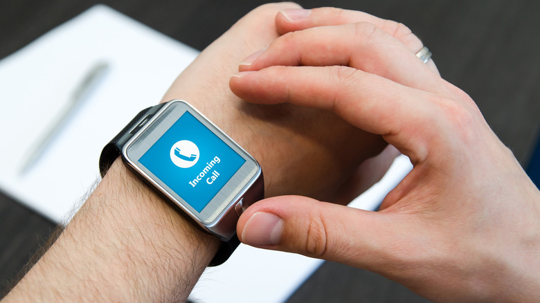 A close-up of a smartwatch receiving an incoming call on a man's wrist