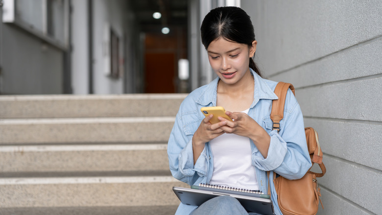 A student reading ebooks on a phone