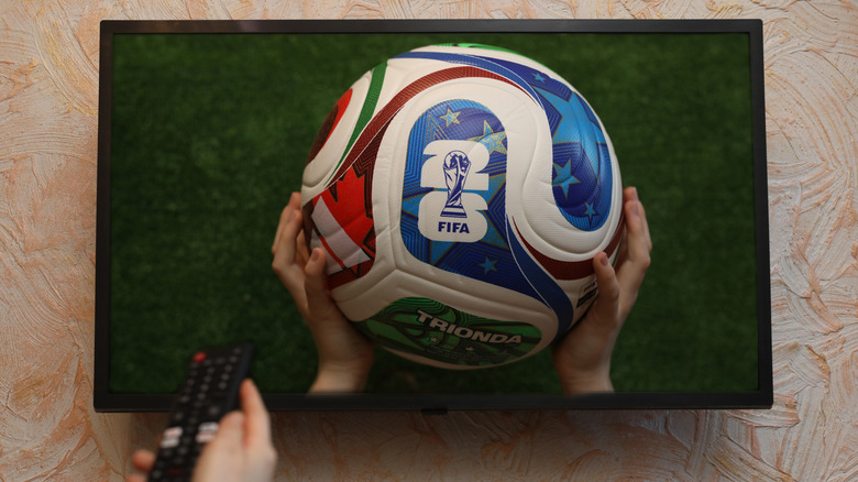 Person using remote while watching sports on TV