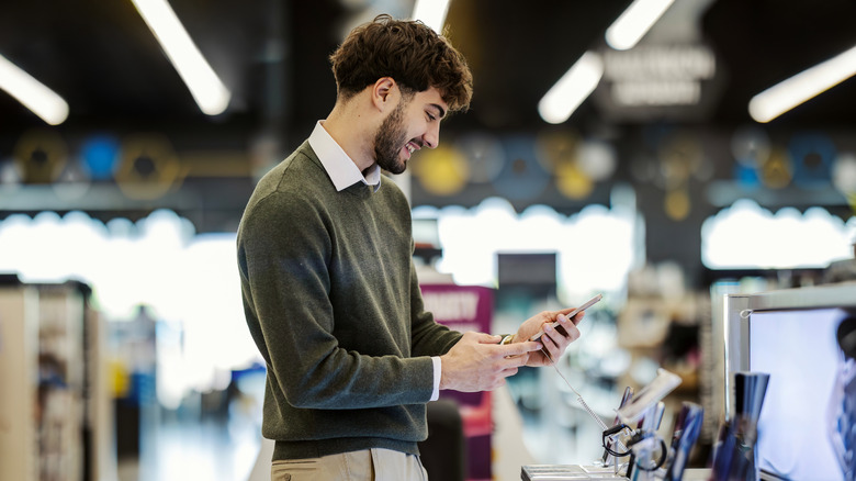 Looking at a phone for purchase in an electronics store