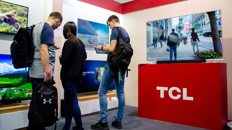 People standing in a TCL TV display section