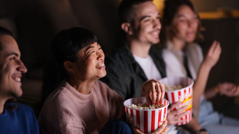 a group of people having popcorn and enjoying a movie or TV series together