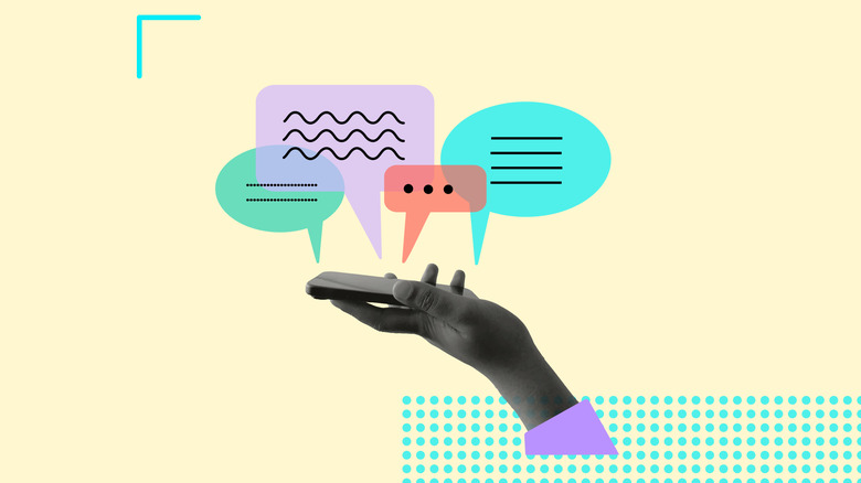 Hand holding phone with colorful messaging icons appearing about it