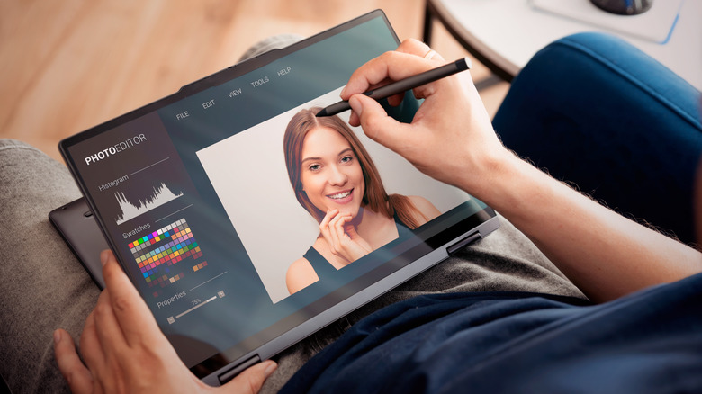 A person working on a 2-in-1 laptop with a pen