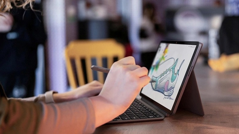 A person using the Lenovo Duet Gen 9 2-in-1 Chromebook on a desk with a stylus