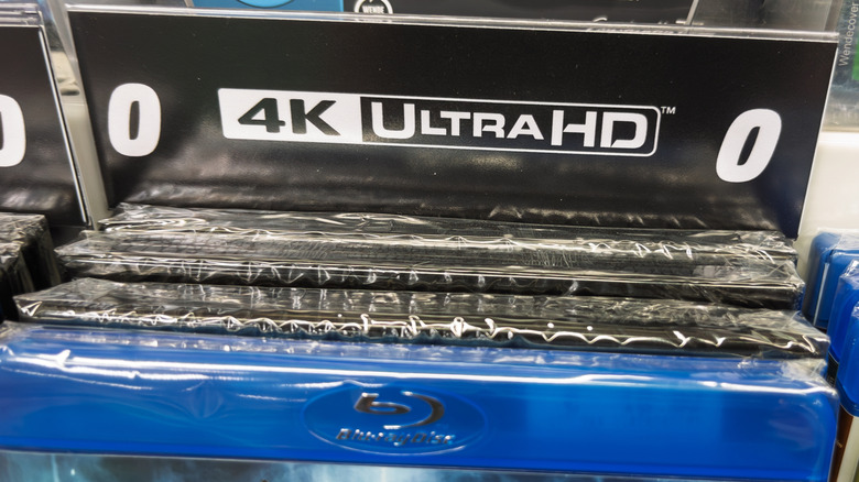 A closeup of the 4K UHD logo, and a Blu-Ray case in front of it.