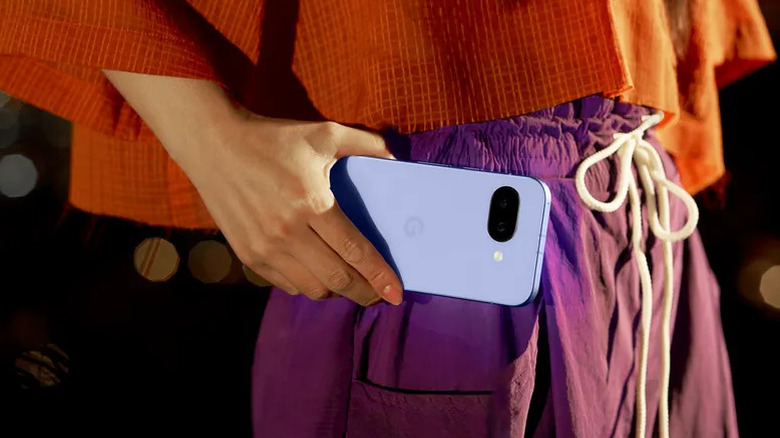 A lady holding a purple Google Pixla 9a phone at waist height