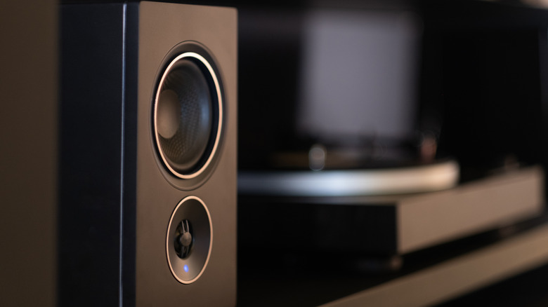 Home threater speaker connected to a bluetooth reciever on a blurred home cinema setup background