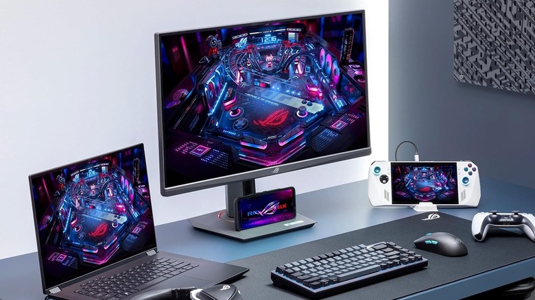 The Asus ROG Strix XG27ACS on a desk in the middle of other Asus hardware