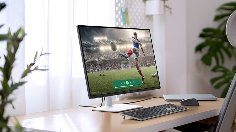 The Dell S2725QS monitor on a desk with a keyboard, laptop, and mouse