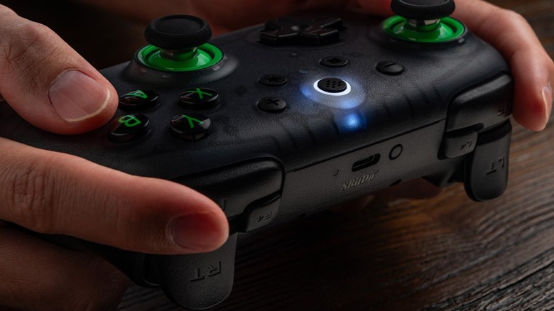 A person holding the 8BitDo Ultimate 2C Wireless Controller.