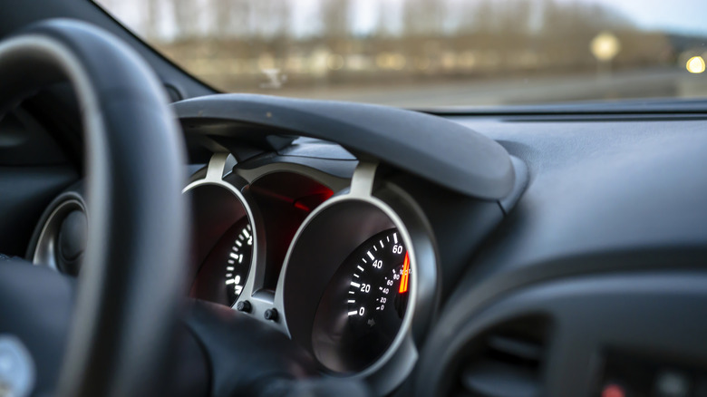 The interiors of a car including the steering wheel and the speedometer