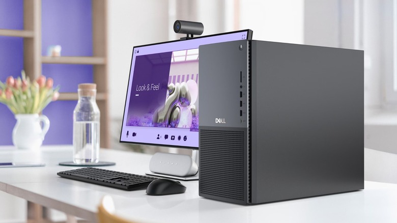 A Dell Tower Plus EBT2250 Gaming PC sits on a white desk next to a display, mouse, keyboard, and other items