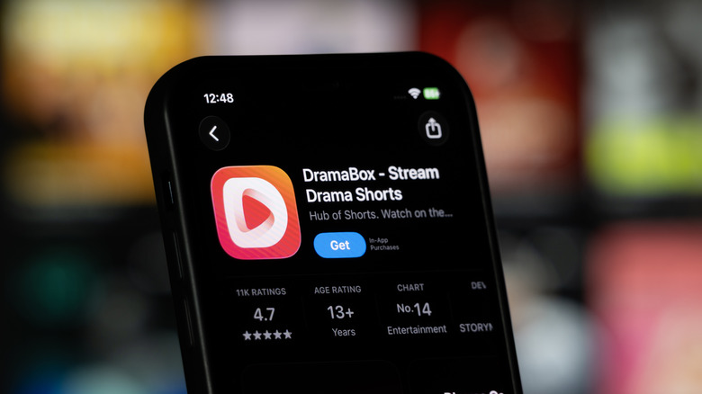A closeup of a smartphone displaying the Apple App Store page for DramaBox, a microdrama app