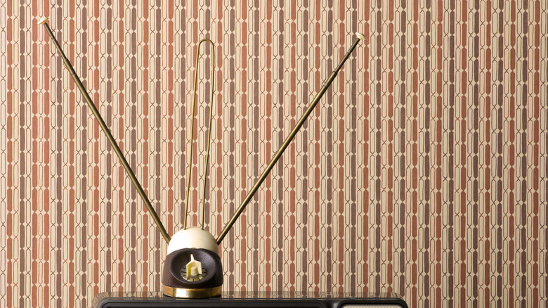 Rabbit ears on top of an analog TV.