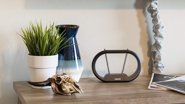 The Philips Rabbit Ears Indoor TV Antenna set up on a TV stand.
