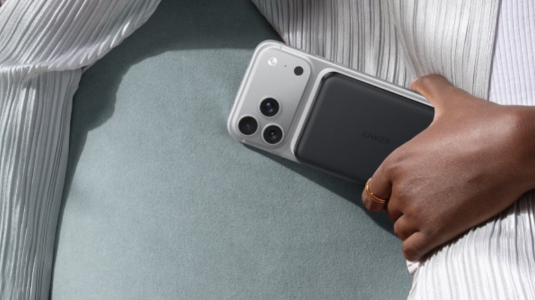 A person holding an iPhone with Anker's slim MaGo Power Bank