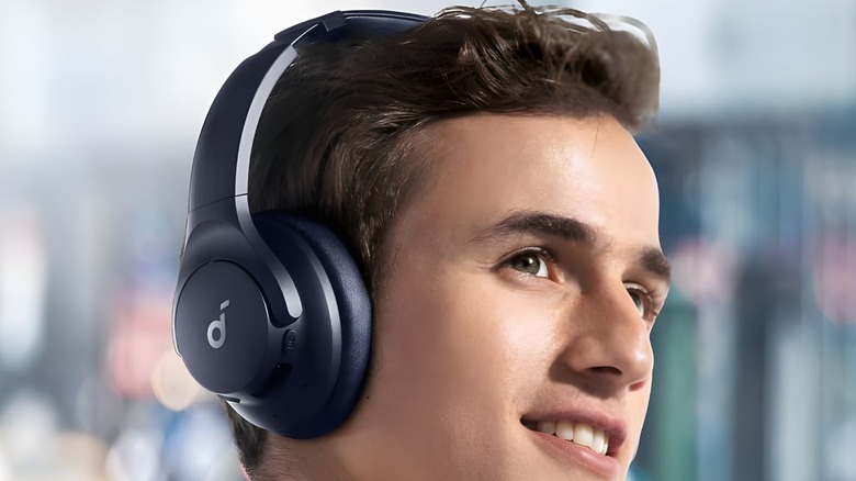 A side profile of a man wearing Soundcore Q20i headphones