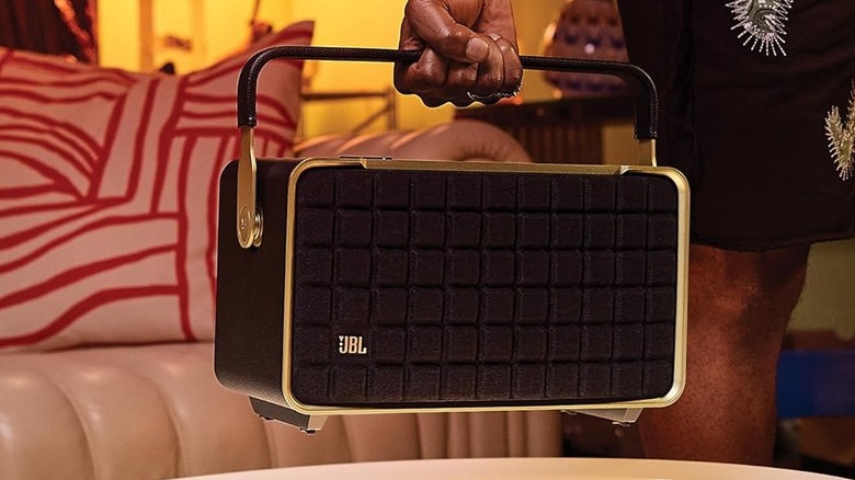 A person holding the JBL Authentics 300 inside a house.
