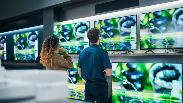 Two people shopping for a TV at a store