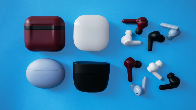 Assorted earbuds and their cases on blue background
