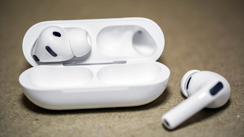The Apple AirPods Pro 3, one in and another out of the case.