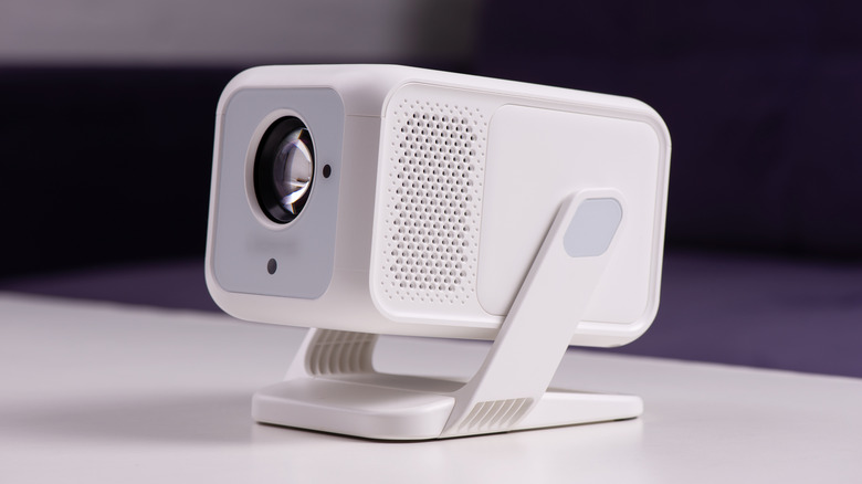 A portable projector placed on a table.