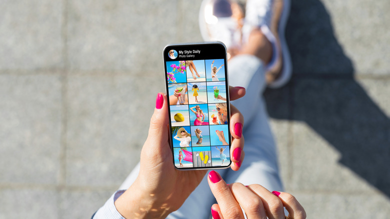 A woman browsing through pictures in her smartphone gallery