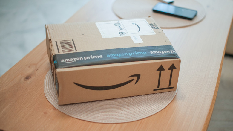 Amazon Prime delivery box sitting on a wooden table with branded tape and a shipping label.