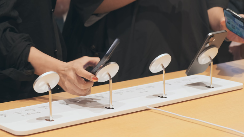 iPhone models placed on a MagSafe accessory at an Apple Store