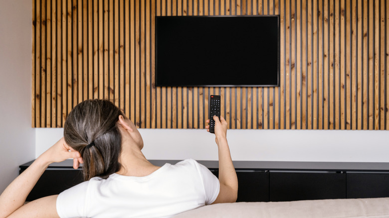 Woman holding remote with black TV screen