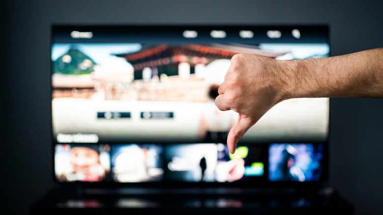 Thumbs down gesture in front of TV