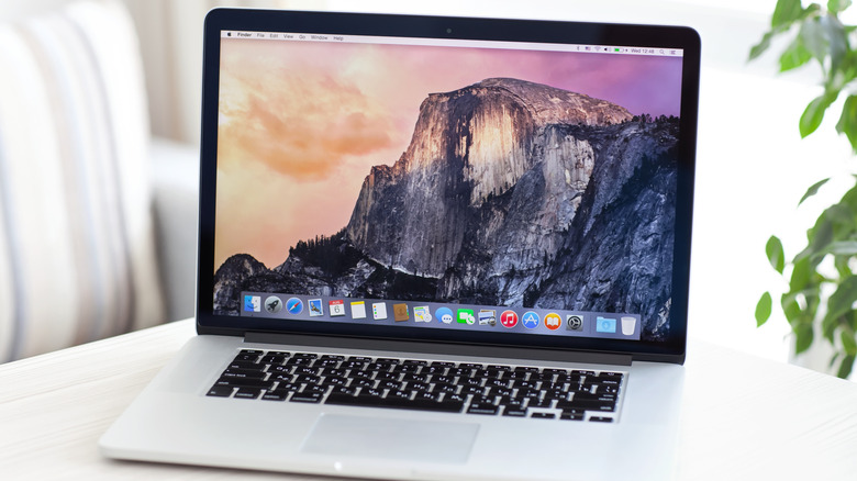 A silver MacBook with a wallpaper showing a mountain