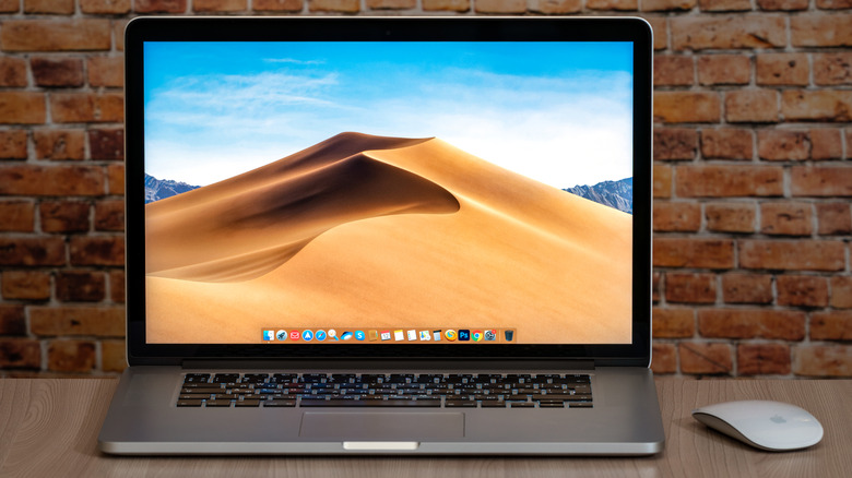 A MacBook with accompanying mouse sitting on a table