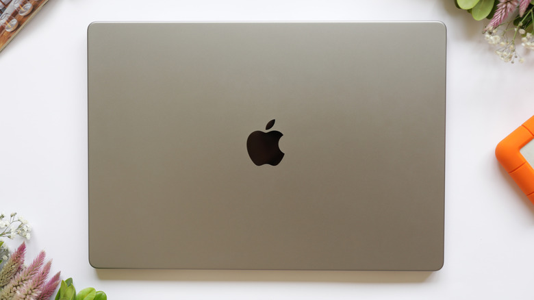 A silver MacBook sitting on a white table