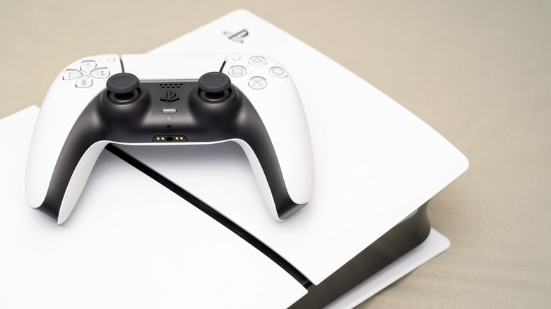 A DualSense controller overlayed on top of a PlayStation 5 console against a beige surface