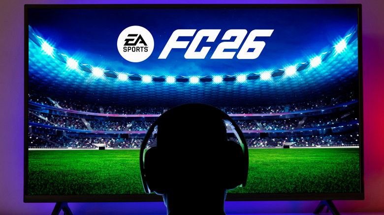 A person playing EA Sports FC 26 on a TV with a PlayStation 5