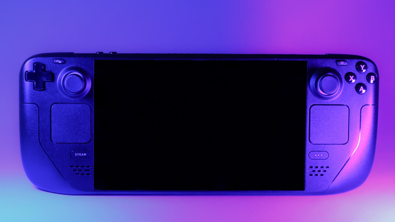 A Steam Deck on a table in colorful lighting.