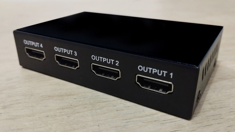 Black 1x4 HDMI splitter on table.