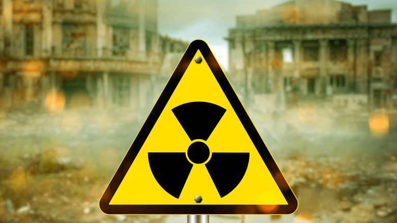 Radiation sign in front of ruined buildings