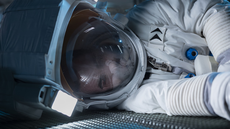 Astronaut lying on spaceship floor