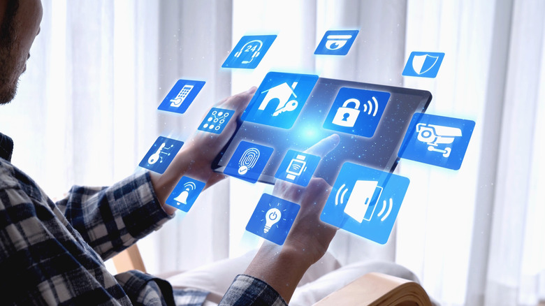 Person holding tablet with smart home graphics