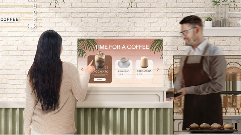 A customer using a transparent touchscreen OLED in a coffee shop